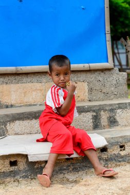 Inle Lake, Myanmar - 30 Ağustos 2016: Kırmızı gömlekli tanımlanamayan Birmanya lı küçük gitl. Myanma halkının yüzde 68'i Bamar etnik grubuna mensandı