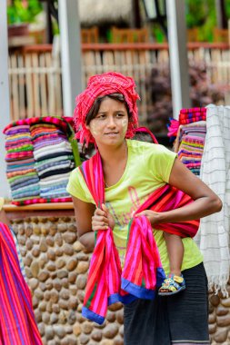 Inle Lake, Myanmar - 30 Ağustos 2016: Kimliği belirsiz birmanyalı kız ve sırtında küçük bir bebek. Myanma halkının yüzde 68'i Bamar etnik grubuna mensandı