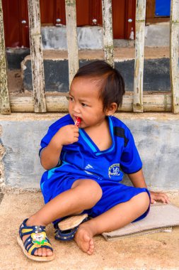 Inle Lake, Myanmar - 30 Ağustos 2016: Sokakta Chelsea forması giyen kimliği belirsiz bir manyacık çocuk. Myanma halkının yüzde 68'i Bamar etnik grubuna mensandı