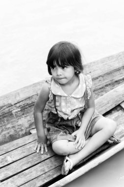 Inle Lake, Myanmar - 30 Ağustos 2016: Ahşap bir teknede tanımlanamayan Birmanyalı küçük kız. Myanma halkının yüzde 68'i Bamar etnik grubuna mensandı