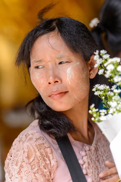 Yangon, Myanmar - 24 Ağustos 2016: Bir tapınakta boyalı yüzü olan kimliği belirsiz Birmanyalı kadın. Myanma halkının yüzde 68'i Bamar etnik grubuna mensandı