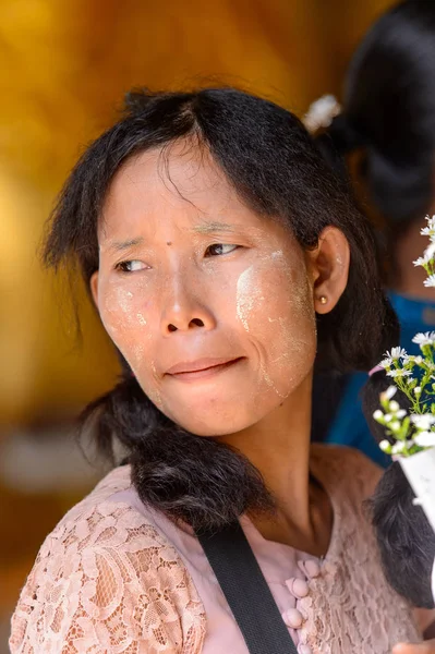 Yangon, Myanmar - 24 Ağustos 2016: Bir tapınakta boyalı yüzü olan kimliği belirsiz Birmanyalı kadın. Myanma halkının yüzde 68'i Bamar etnik grubuna mensandı