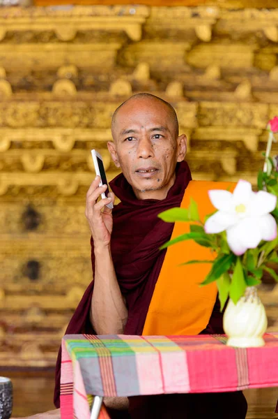 Yangon, Myanmar - 24 Ağustos 2016: Tanımlanamayan Birmanyalı Budist keşiş telefonda konuşuyor. Myanma halkının yüzde 68'i Bamar etnik grubuna mensandı