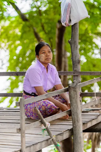 Inwa, Myanmar - 25 Ağustos 2016: Tanımlanamayan Birmanyalı kadın oturuyor. Myanma halkının yüzde 68'i Bamar etnik grubuna mensandı