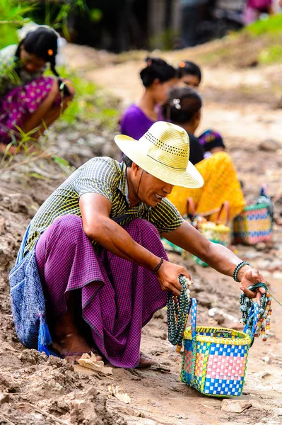 Inwa, Myanmar - 25 Ağustos 2016: Tanımlanamayan Birmanyalı adam satılık hediyelik eşya lar sunuyor. Myanma halkının yüzde 68'i Bamar etnik grubuna mensandı