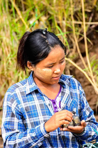 Inwa, Myanmar - 25 Ağustos 2016: Tanımlanamayan Birmanyalı kız satılık hediyelik eşya lar sunuyor. Myanma halkının yüzde 68'i Bamar etnik grubuna mensandı