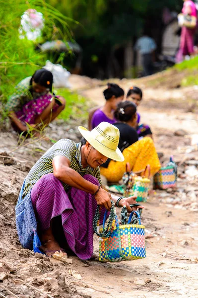 Inwa, Myanmar - 25 Ağustos 2016: Tanımlanamayan Birmanyalı adam satılık hediyelik eşya lar sunuyor. Myanma halkının yüzde 68'i Bamar etnik grubuna mensandı