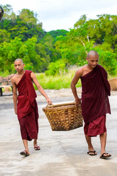 Inwa, Myanmar - 25 Ağustos 2016: Tanımlanamayan Birmanyalı Budist rahipler bir sepet taşıyor. Myanma halkının yüzde 68'i Bamar etnik grubuna mensandı