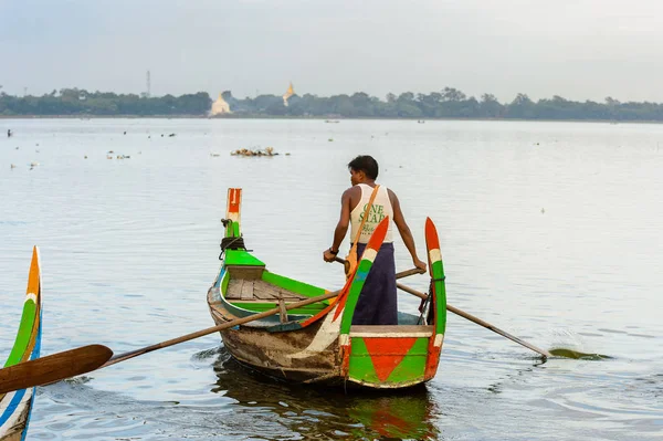 Taungthaman Gölü, Myanmar - 25 Ağustos 2016: Myanmar'ın eski başkenti Amarapura yakınlarındaki Taungthaman Gölü üzerinde seyreden bir teknedeki kimliği belirsiz Birmanyalı adam