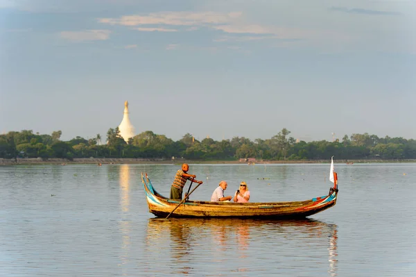 Taungthaman Gölü, Myanmar - 25 Ağustos 2016: Kimliği belirsiz Birmanyalı adam, Myanmar'ın eski başkenti Amarapura yakınlarındaki Taungthaman Gölü üzerinde turistlerle birlikte bir tekneyle yelken açtı