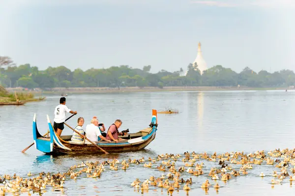 Taungthaman Gölü, Myanmar - 25 Ağustos 2016: Kimliği belirsiz Birmanyalı adam, Myanmar'ın eski başkenti Amarapura yakınlarındaki Taungthaman Gölü üzerinde turistlerle birlikte bir tekneyle yelken açtı