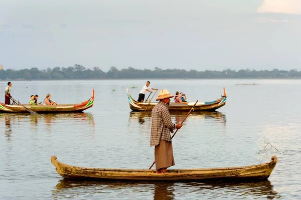 Taungthaman Gölü, Myanmar - 25 Ağustos 2016: Myanmar'ın eski başkenti Amarapura yakınlarındaki Taungthaman Gölü üzerinde seyreden bir teknedeki kimliği belirsiz Birmanyalı adam