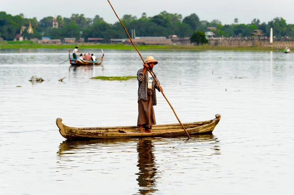 Taungthaman Gölü, Myanmar - 25 Ağustos 2016: Myanmar'ın eski başkenti Amarapura yakınlarındaki Taungthaman Gölü üzerinde seyreden bir teknedeki kimliği belirsiz Birmanyalı adam