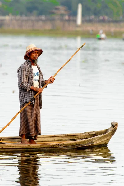 Taungthaman Gölü, Myanmar - 25 Ağustos 2016: Myanmar'ın eski başkenti Amarapura yakınlarındaki Taungthaman Gölü üzerinde seyreden bir teknedeki kimliği belirsiz Birmanyalı adam