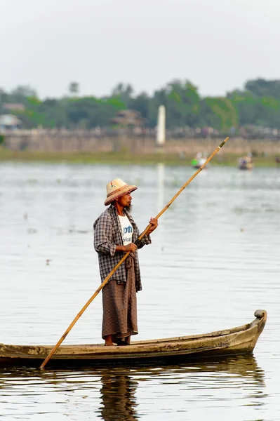 Taungthaman Gölü, Myanmar - 25 Ağustos 2016: Myanmar'ın eski başkenti Amarapura yakınlarındaki Taungthaman Gölü üzerinde seyreden bir teknedeki kimliği belirsiz Birmanyalı adam