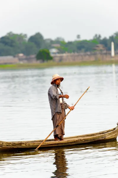 Taungthaman Gölü, Myanmar - 25 Ağustos 2016: Myanmar'ın eski başkenti Amarapura yakınlarındaki Taungthaman Gölü üzerinde seyreden bir teknedeki kimliği belirsiz Birmanyalı adam