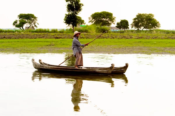 Taungthaman Gölü, Myanmar - 25 Ağustos 2016: Myanmar'ın eski başkenti Amarapura yakınlarındaki Taungthaman Gölü üzerinde seyreden bir teknedeki kimliği belirsiz Birmanyalı adam