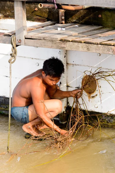 Mandalay, Myanmar - 26 Ağustos 2016: Tanımlanamayan Birmanyalı çocuk tekne motorunu çimlerden temizliyor. Myanma halkının yüzde 68'i Bamar etnik grubuna mensandı