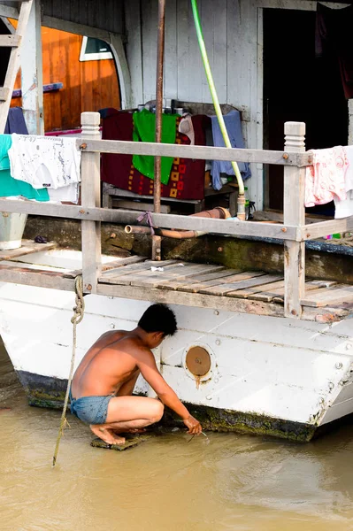 Mandalay, Myanmar - 26 Ağustos 2016: Tanımlanamayan Birmanyalı çocuk tekne motorunu çimlerden temizliyor. Myanma halkının yüzde 68'i Bamar etnik grubuna mensandı