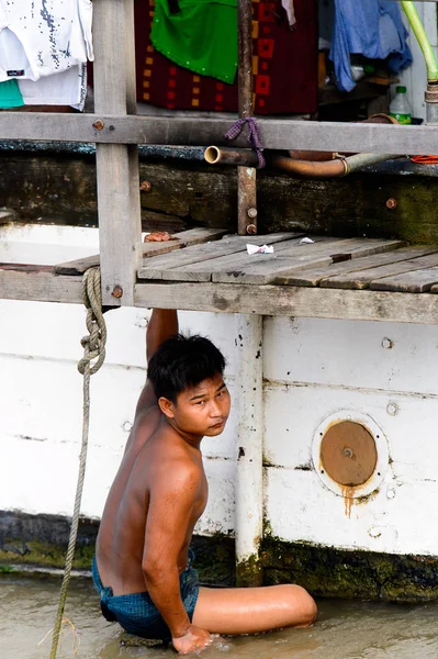 Mandalay, Myanmar - 26 Ağustos 2016: Tanımlanamayan Birmanyalı çocuk tekne motorunu çimlerden temizliyor. Myanma halkının yüzde 68'i Bamar etnik grubuna mensandı