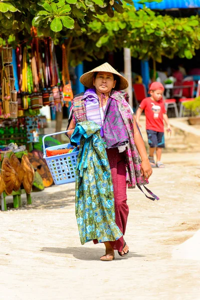 Mingun, Myanmar - 26 Ağustos 2016: Kimliği belirsiz Birmanyalı kadın satın almak için kıyafet sunuyor. Myanma halkının yüzde 68'i Bamar etnik grubuna mensandı