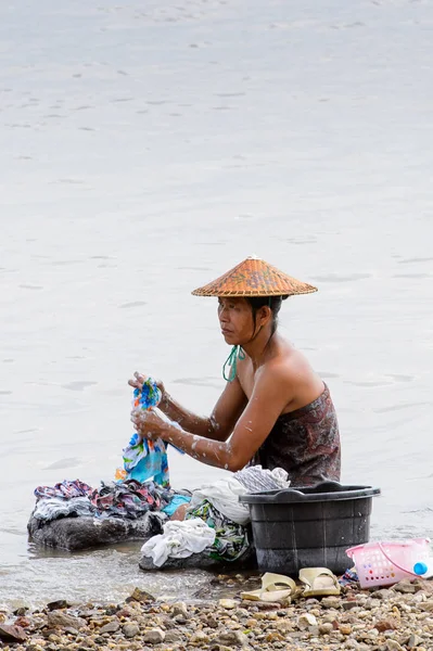 Irrawaddy Nehri, Myanmar - 26 Ağustos 2016: Kimliği belirsiz Birmanyalı çocuk Myanmar'daki Irrawaddy Nehri'nde giysi temizliyor. Bu en büyük rive ve en önemli ticari su yolu