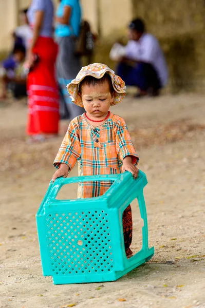Mingun, Myanmar - 26 Ağustos 2016: Boyalı suratlı kimliği belirsiz Birmanyalı kız sokakta oynuyor. Myanma halkının yüzde 68'i Bamar etnik grubuna mensandı
