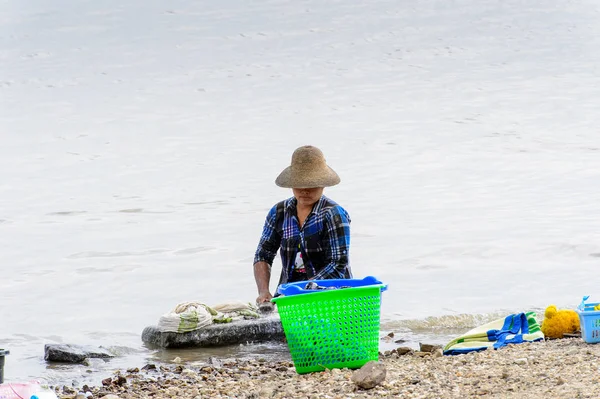 Irrawaddy Nehri, Myanmar - 26 Ağustos 2016: Kimliği belirsiz Birmanyalı kız, Myanmar'ın Irrawaddy Nehri'ndeki giysilerini temizliyor. Bu en büyük rive ve en önemli ticari su yolu