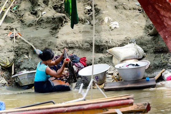 Mandalay, Myanmar - 26 Ağustos 2016: Kimliği belirsiz Birmanyalı kadın sudaki kıyafetleri temizliyor. Myanma halkının yüzde 68'i Bamar etnik grubuna mensandı