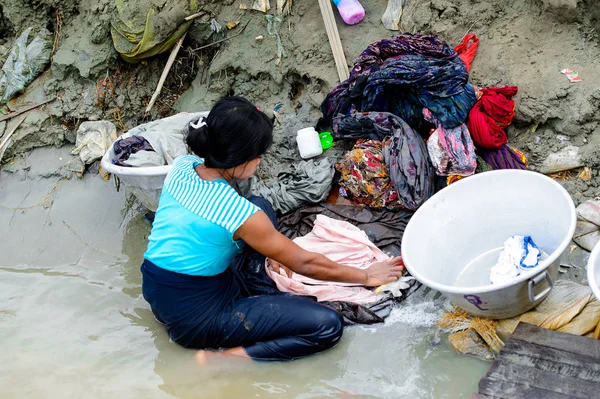 Mandalay, Myanmar - 26 Ağustos 2016: Kimliği belirsiz Birmanyalı kadın sudaki kıyafetleri temizliyor. Myanma halkının yüzde 68'i Bamar etnik grubuna mensandı