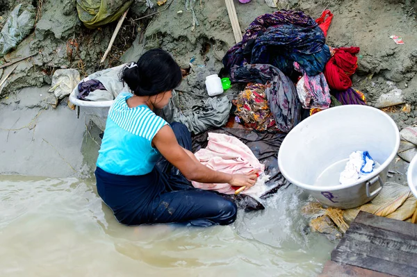 Mandalay, Myanmar - 26 Ağustos 2016: Kimliği belirsiz Birmanyalı kadın sudaki kıyafetleri temizliyor. Myanma halkının yüzde 68'i Bamar etnik grubuna mensandı