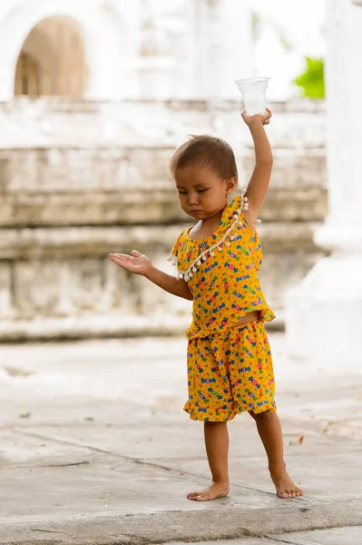 Mandalay, Myanmar - 26 Ağustos 2016: Tanımlanamayan Birmanyalı küçük kız sokakta oynuyor. Myanma halkının yüzde 68'i Bamar etnik grubuna mensandı