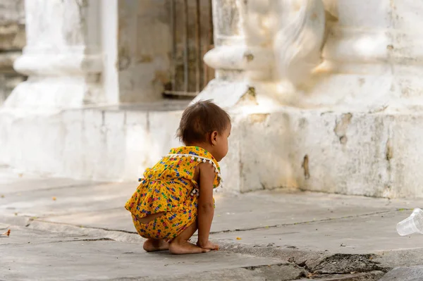 Mandalay, Myanmar - 26 Ağustos 2016: Tanımlanamayan Birmanyalı küçük kız sokakta oynuyor. Myanma halkının yüzde 68'i Bamar etnik grubuna mensandı