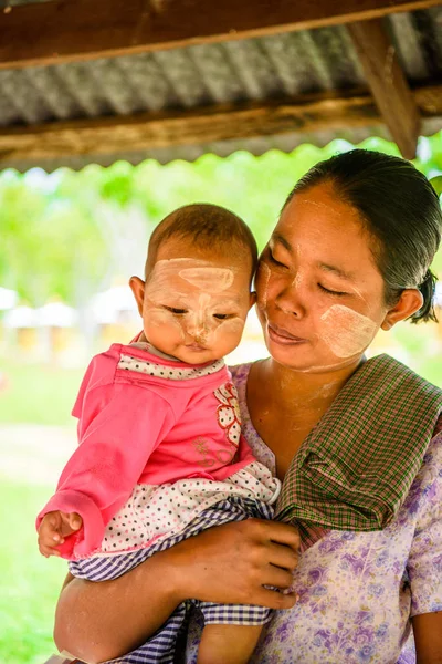 Monywa, Myanmar - 27 Ağustos 2016: Çocuğuyla birlikte kimliği belirsiz Birmanyalı anne. Myanma halkının yüzde 68'i Bamar etnik grubuna mensandı