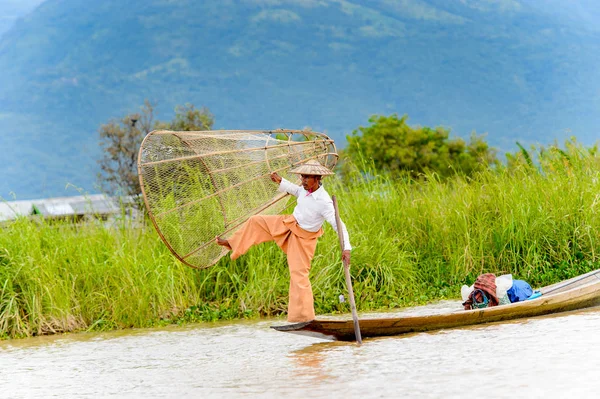 Inle Lake, Myanmar - 30 Ağustos 2016: Özel el yapımı ağı olan bir teknede tanımlanamayan Birmanyalı balıkçı. Bu Myanmar balıkçılık geleneksel yoludur