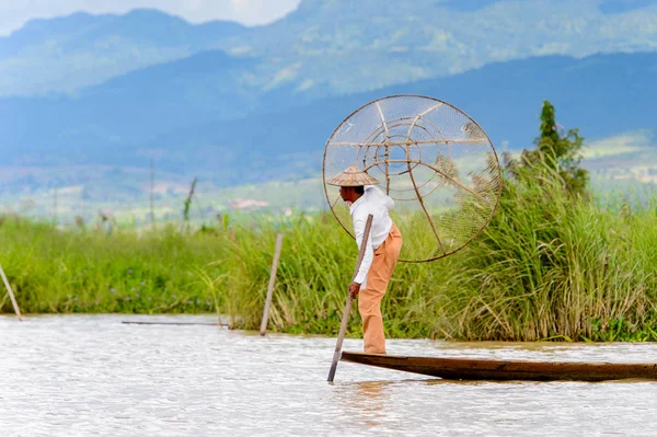 Inle Lake, Myanmar - 30 Ağustos 2016: Özel el yapımı ağı olan bir teknede tanımlanamayan Birmanyalı balıkçı. Bu Myanmar balıkçılık geleneksel yoludur