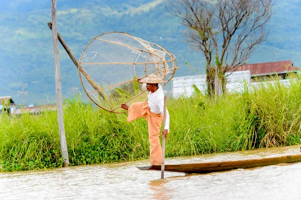 Inle Lake, Myanmar - 30 Ağustos 2016: Özel el yapımı ağı olan bir teknede tanımlanamayan Birmanyalı balıkçı. Bu Myanmar balıkçılık geleneksel yoludur