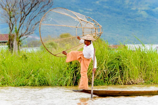 Inle Lake, Myanmar - 30 Ağustos 2016: Özel el yapımı ağı olan bir teknede tanımlanamayan Birmanyalı balıkçı. Bu Myanmar balıkçılık geleneksel yoludur