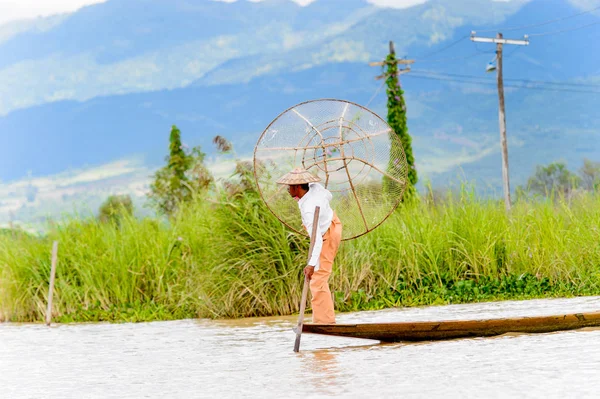 Inle Lake, Myanmar - 30 Ağustos 2016: Özel el yapımı ağı olan bir teknede tanımlanamayan Birmanyalı balıkçı. Bu Myanmar balıkçılık geleneksel yoludur