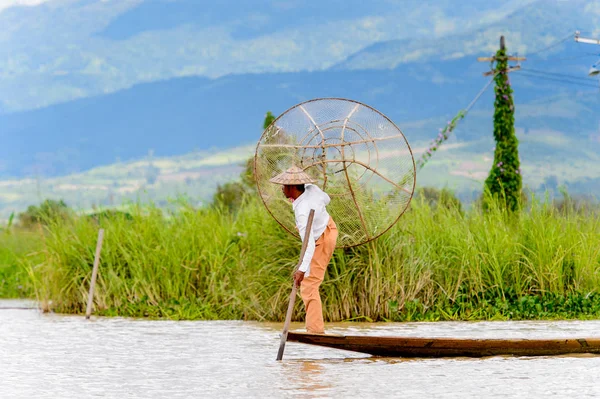 Inle Lake, Myanmar - 30 Ağustos 2016: Özel el yapımı ağı olan bir teknede tanımlanamayan Birmanyalı balıkçı. Bu Myanmar balıkçılık geleneksel yoludur