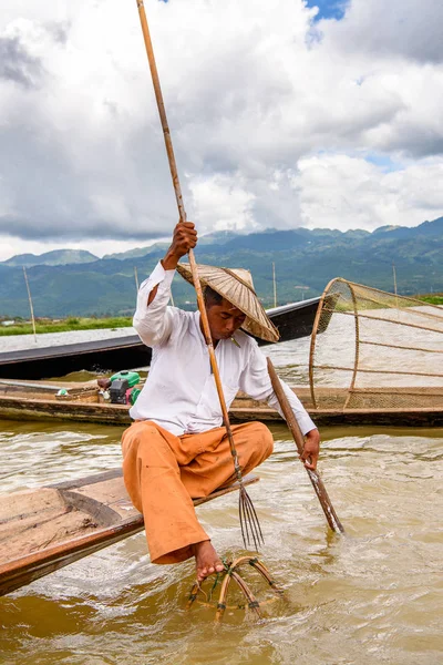 Inle Lake, Myanmar - 30 Ağustos 2016: Özel el yapımı ağı olan bir teknede tanımlanamayan Birmanyalı balıkçı. Bu Myanmar balıkçılık geleneksel yoludur