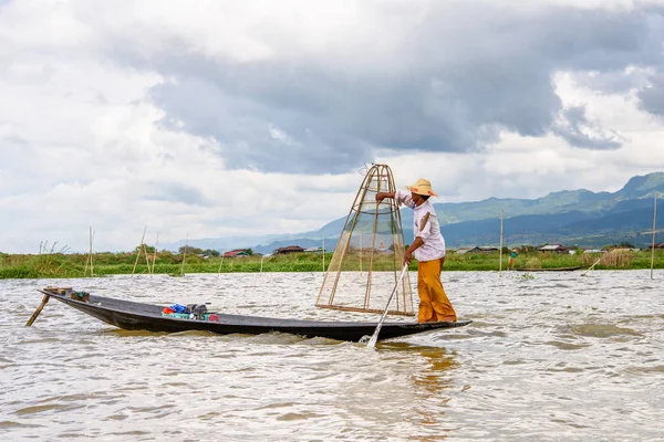 Inle Lake, Myanmar - 30 Ağustos 2016: Özel el yapımı ağı olan bir teknede tanımlanamayan Birmanyalı balıkçı. Bu Myanmar balıkçılık geleneksel yoludur