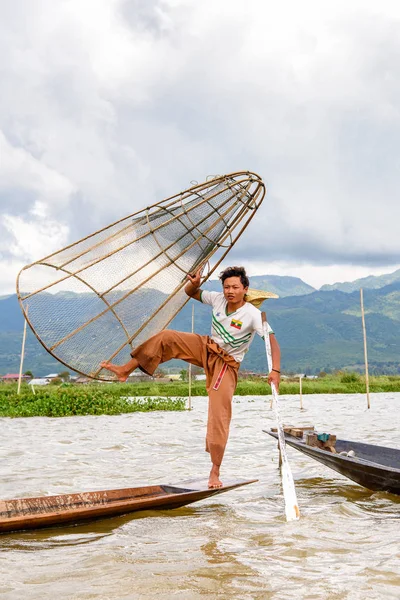 Inle Lake, Myanmar - 30 Ağustos 2016: Özel el yapımı ağı olan bir teknede tanımlanamayan Birmanyalı balıkçı. Bu Myanmar balıkçılık geleneksel yoludur