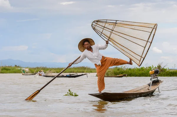 Inle Lake, Myanmar - 30 Ağustos 2016: Tanımlanamayan Birmanyalı balıkçı, özel el yapımı ağı olan bir teknede dengeyapıyor. Bu Myanmar balıkçılık geleneksel yoludur