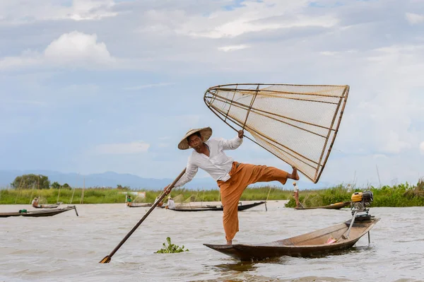 Inle Lake, Myanmar - 30 Ağustos 2016: Özel el yapımı ağı olan bir teknede tanımlanamayan Birmanyalı balıkçı. Bu Myanmar balıkçılık geleneksel yoludur