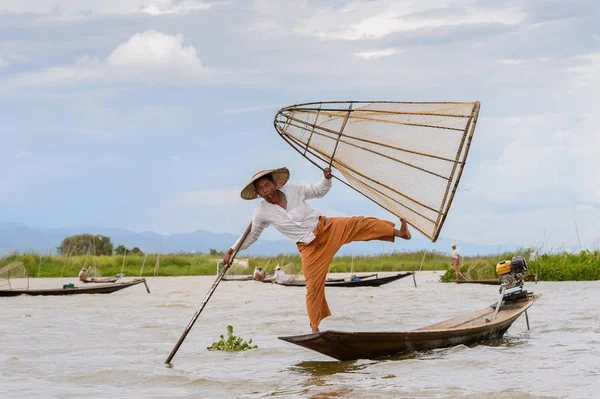 Inle Lake, Myanmar - 30 Ağustos 2016: Tanımlanamayan Birmanyalı balıkçı, özel el yapımı ağı olan bir teknede dengeyapıyor. Bu Myanmar balıkçılık geleneksel yoludur