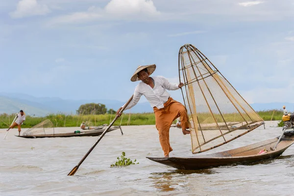 Inle Lake, Myanmar - 30 Ağustos 2016: Özel el yapımı ağı olan bir teknede tanımlanamayan Birmanyalı balıkçı. Bu Myanmar balıkçılık geleneksel yoludur