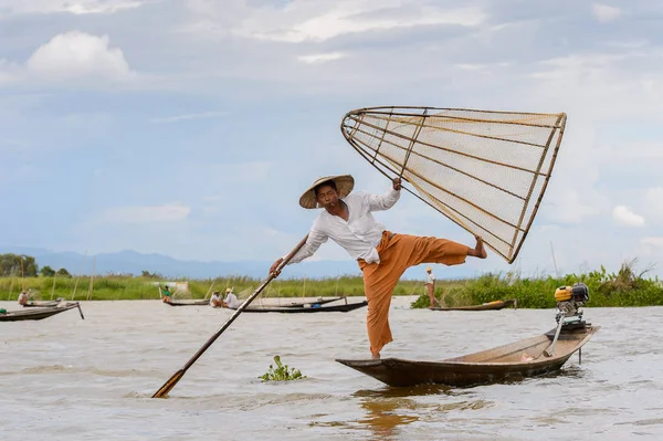 Inle Lake, Myanmar - 30 Ağustos 2016: Tanımlanamayan Birmanyalı balıkçı, özel el yapımı ağı olan bir teknede dengeyapıyor. Bu Myanmar balıkçılık geleneksel yoludur