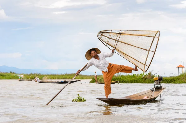 Inle Lake, Myanmar - 30 Ağustos 2016: Tanımlanamayan Birmanyalı balıkçı, özel el yapımı ağı olan bir teknede dengeyapıyor. Bu Myanmar balıkçılık geleneksel yoludur