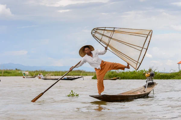 Inle Lake, Myanmar - 30 Ağustos 2016: Tanımlanamayan Birmanyalı balıkçı, özel el yapımı ağı olan bir teknede dengeyapıyor. Bu Myanmar balıkçılık geleneksel yoludur